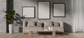 A contemporary living room features a grey couch, a coffee table, and frames mockup on a loft wall Royalty Free Stock Photo