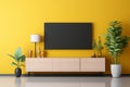 Contemporary living space boasts a TV wall console with table, lamp, and plant on a bright yellow wall