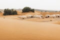 Contemporary luxury eco glamping camp Morocco Sahara desert. Sand dunes around