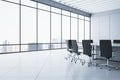 Contemporary meeting room interior with concrete flooring and panoramic window with city view and daylight. Commercial office Royalty Free Stock Photo