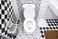Modern bathroom design featuring artistic wall patterns and checkerboard tiles. Royalty Free Stock Photo