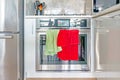 Contemporary, modern chrome stove and oven range, with color screen clock, and green and red dish towels hanging on the oven