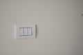 Contemporary modern electric light switches on on a light living room wall. House home utilities interior details elements Royalty Free Stock Photo