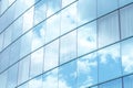 Contemporary office building with reflective glass panels that mirror blue sky and white clouds, building blending with the sky. Royalty Free Stock Photo