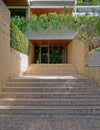 A contemporary residential apartment building entrance stairs with light brown brick walls.