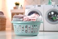 A contemporary room showcasing a washing machine, dryer, and a folded laundry basket