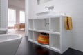 Minimalist white painted bathroom unit, with colourful basket and black flooring