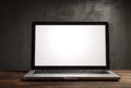 Modern Silver Laptop Open With Blank White Screen Displaying On Rustic Wooden Table Against Dark Textured Wall Royalty Free Stock Photo
