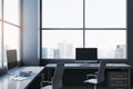 Contemporary spacious dark coworking office interior with panoramic windows and city view. Workplace concept. Royalty Free Stock Photo