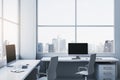 Contemporary spacious light coworking office interior with panoramic windows and city view. Workplace concept. Royalty Free Stock Photo