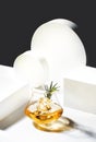 Contemporary still life with whiskey, scotch or bourbon glass with rosemary, shard ice on black white background with geometric