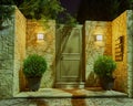 A contemporary three - family house entrance door by the sidewalk night view.