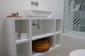 Contemporary white painted bathroom unit, with colourful basket and black flooring
