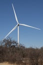 A contemporary wind turbine in a winter lanscape with blue sky