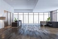 Contemporary wooden and concrete office lobby interior with reception desk, panoramic window with city view and other objects. Royalty Free Stock Photo