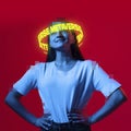 Contemporay artwork. Ypung smiling woman with neon lettering around head over red background