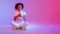 Content black woman cellphone on neon pink glow Royalty Free Stock Photo