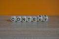 Content and context symbol. Turned a wooden cubes and changed the word context to content. Beautiful wooden table, orange