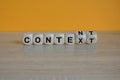 Content and context symbol. Turned wooden cubes and changed the word context to content. Beautiful orange table, orange background Royalty Free Stock Photo