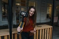 Content creator, blogger, vlogger young woman taking selfies, filming herself and having fun on city street.