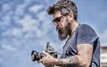Content creator. Man bearded hipster photographer. Old but still good. Manual settings. Photographer hold vintage camera