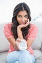 Content cute brunette sitting on couch holding remote Royalty Free Stock Photo