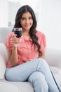 Content cute brunette sitting on couch holding wine glass Royalty Free Stock Photo