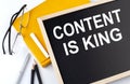 CONTENT IS KING text on the blackboard with notepad , pen, pencil Royalty Free Stock Photo