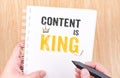 Content is King work on white ring binder notebook with hand holding pencil on wood table,Digital Business concept Royalty Free Stock Photo