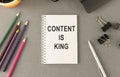 Content is King work on white ring binder notebook with hand holding pencil on wood table Royalty Free Stock Photo