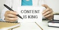 Content is King work on white ring binder notebook with hand holding pencil on wood table,Digital Royalty Free Stock Photo