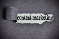 Content marketing word under torn black sugar paper Royalty Free Stock Photo