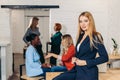 Blonde business woman smiles at camera with colleagues working in background Royalty Free Stock Photo