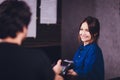 Content satisfied handsome bearded man in earphones giving credit card to waitress while paying for bill in cafe. Royalty Free Stock Photo