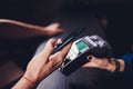 Content satisfied handsome bearded man in earphones giving credit card to waitress while paying for bill in cafe. Royalty Free Stock Photo