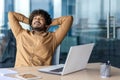 Relaxed young businessman taking a break at the office with laptop Royalty Free Stock Photo