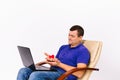 A contented deaf senior man holding a hearing aid and a red heart in front of a laptop camera. Online Charity on white Royalty Free Stock Photo