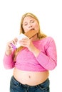 Contented obese woman eating large chocolate bar