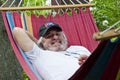 Contented old man finding solace in a hammock. Blissful relaxation for the old man in the hammock. Serene old man enjoying a Royalty Free Stock Photo