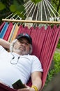 Contented old man finding solace in a hammock. Blissful relaxation for the old man in the hammock. Serene old man enjoying a Royalty Free Stock Photo