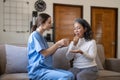 Contented senior woman taking medicines while her caregiver advising her medication. Medication for seniors, nursing Royalty Free Stock Photo