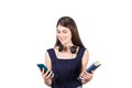 Contented student girl holding a book and her smartphone in hands, isolated on white background. Choosing between a phone and Royalty Free Stock Photo