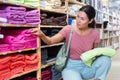 Contented woman choosing toilet towels in textile store closeup