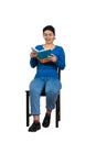 Contented woman student seated on a chair enjoying reading her favorite book isolated over white background Royalty Free Stock Photo