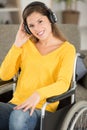 contented woman in wheelchair listening to earphones Royalty Free Stock Photo