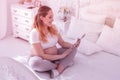 Young long-haired pregnant woman in a white t-shirt looking at x-ray picture Royalty Free Stock Photo