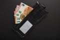 The contents of a man`s wallet - euro notes and bitcoins on a black background