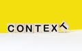 CONTEXT The word is written on wooden cubes and a white and yellow background