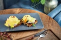 Continental breakfast. Close up view on traditional belgian breakfast served on grey plate on wooden table in cafe. Eggs Benedict Royalty Free Stock Photo