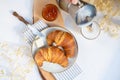 Continental breakfast, a cup of coffee with milk, two croissants, butter and orange jam on a wooden board, top view Royalty Free Stock Photo